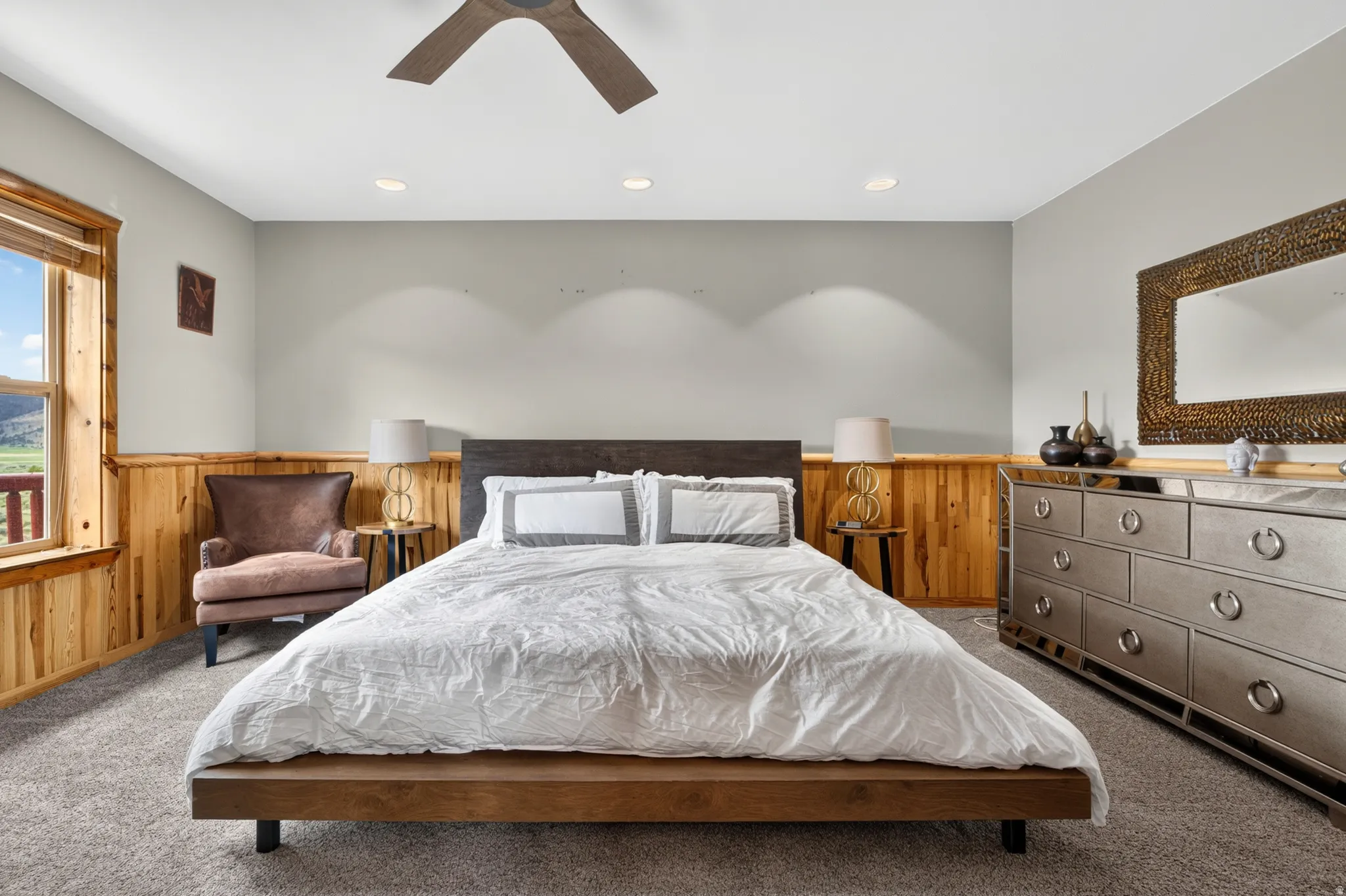 Bedroom featuring wood-finish wainscoting, recessed lighting, and a window with wood trim