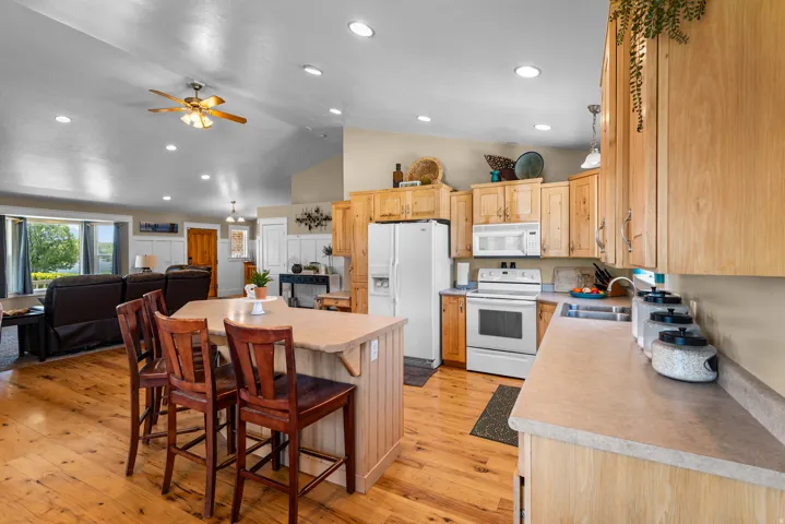 Kitchen featuring wood-finish cabinetry and white appliances, including a refrigerator, microwave, and range