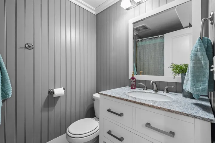 Modern bathroom vanity featuring a white cabinetry base with dual drawers and black hardware, topped with a light-hued stone countertop
