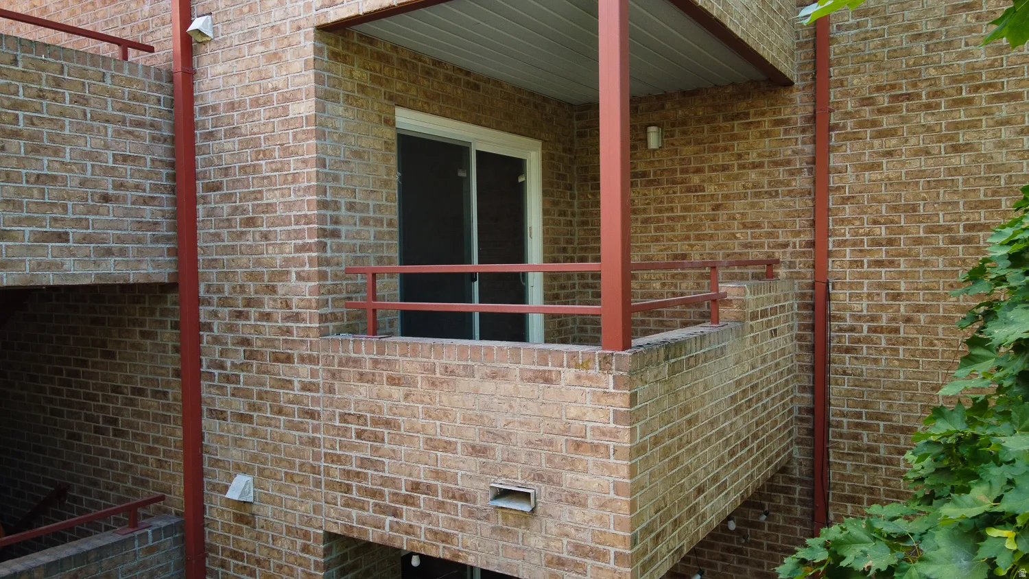 Balcony with brick construction and red metal railings