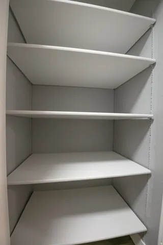 Built-in shelving unit featuring multiple white shelves, gray interior walls, and adjustable shelf supports