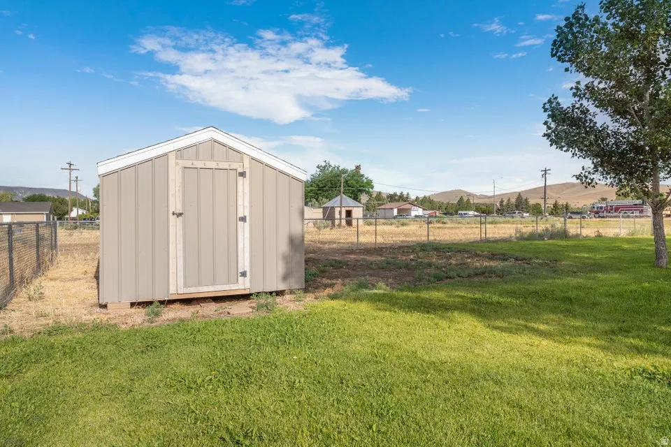 Freestanding storage shed with wood-panel siding and white trim