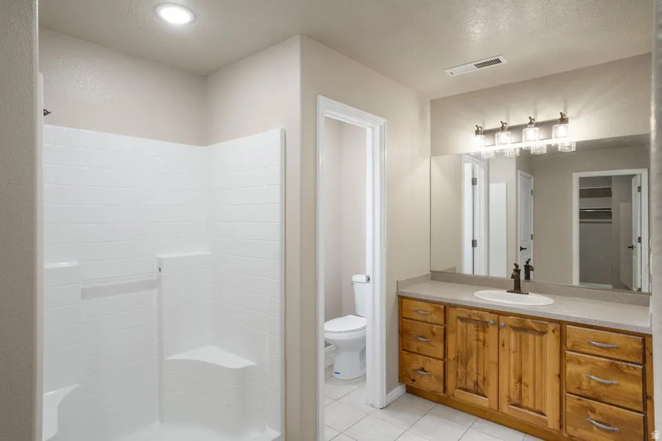 Bathroom vanity with wood-finish cabinetry, a countertop, and an undermount sink