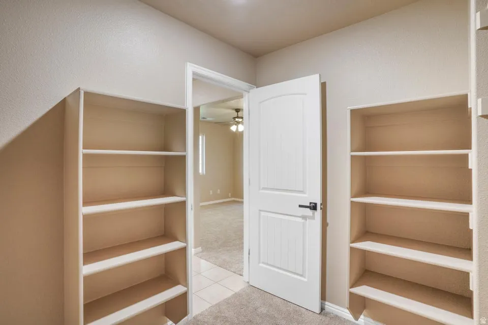 Built-in shelving units flank an arched panel door with matte black hardware