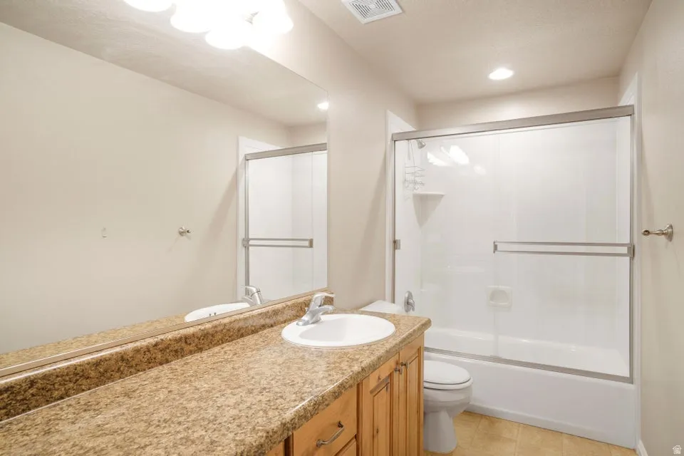 Bathroom vanity with a granite-style countertop, undermount sink, and wood-finish cabinetry