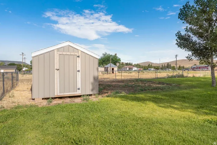 Freestanding storage shed with wood-panel siding and white trim