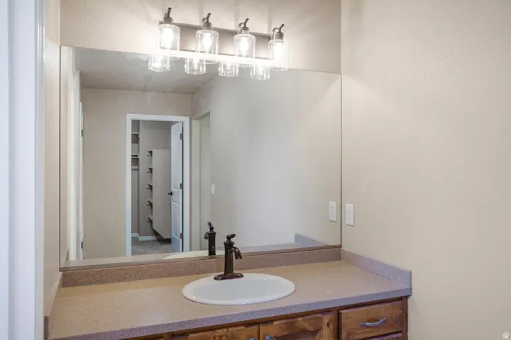 Single vanity with an oval sink, bronze-finish faucet, and coordinating light fixture