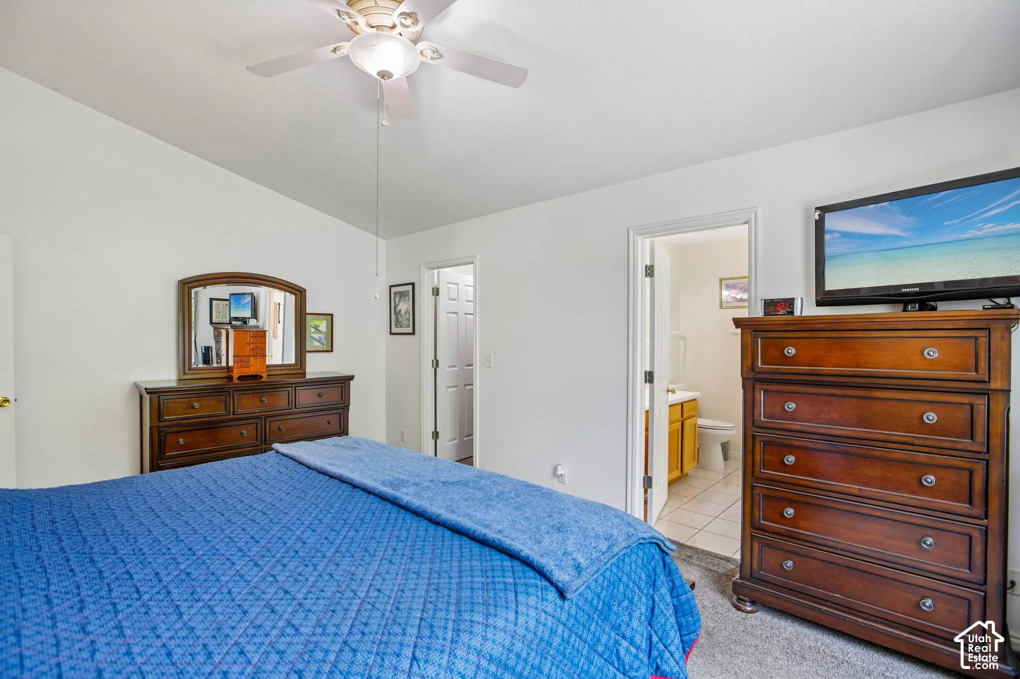 Spacious room featuring vaulted ceilings, a ceiling fan with light fixture, and carpet flooring