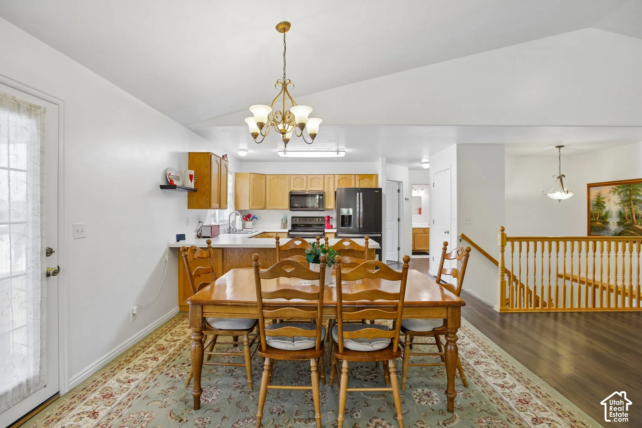 Open-concept dining area featuring a vaulted ceiling and an ornate chandelier