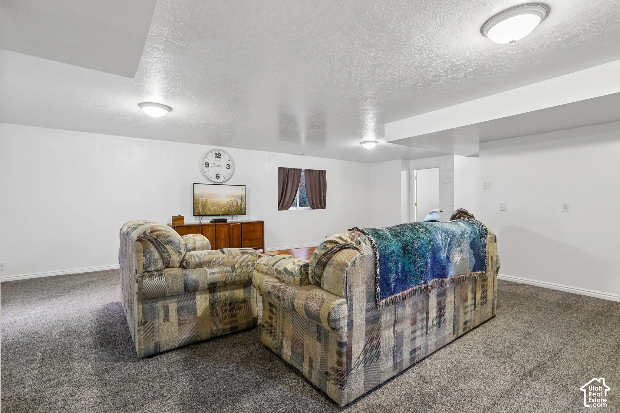 Spacious room featuring neutral carpeting, white walls, and overhead flush-mount lighting