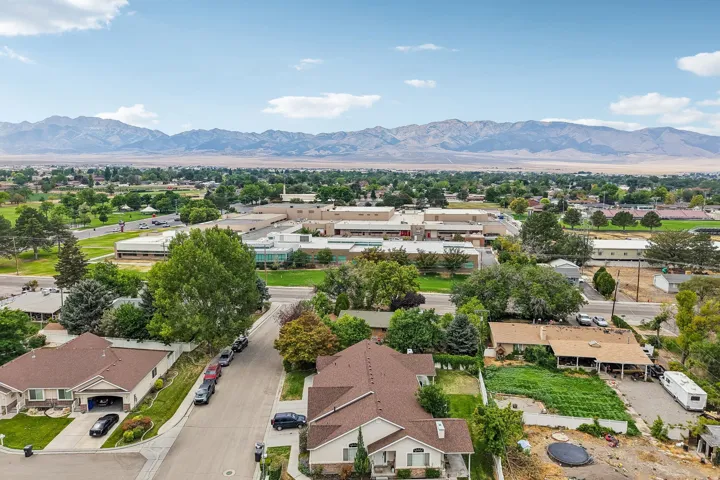 Expansive aerial perspective showcasing a residential neighborhood with distant mountain ranges