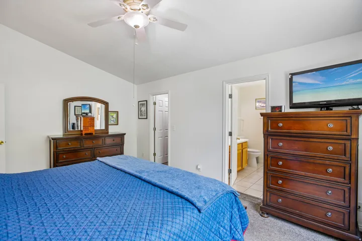 Spacious room featuring vaulted ceilings, a ceiling fan with light fixture, and carpet flooring