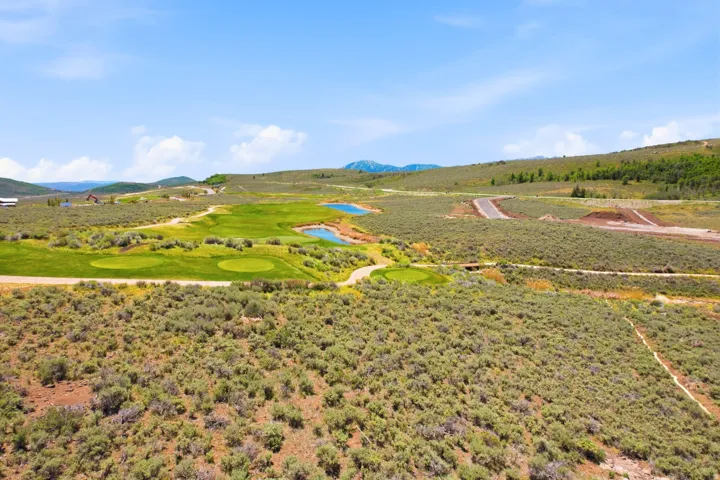 Expansive green golf course with multiple holes, surrounded by natural landscaping, and featuring tranquil water features
