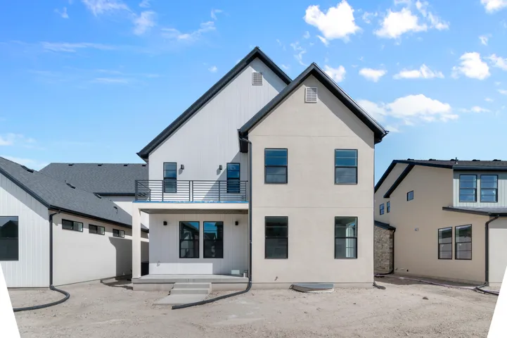 Modern farmhouse exterior with white vertical siding and light-colored stucco