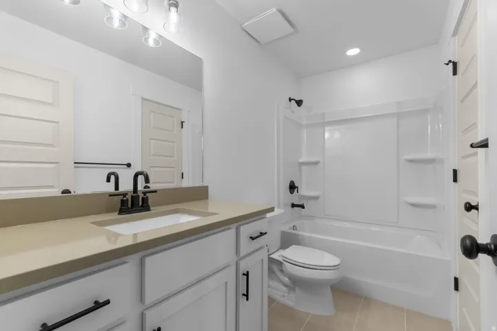 White vanity with matte black hardware, integrated sink, and light-toned countertop