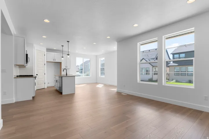 Spacious open-concept layout with wood-finish flooring, recessed lighting, and large windows