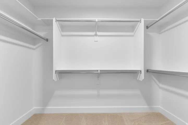 Built-in closet system with multiple hanging rods and integrated shelving