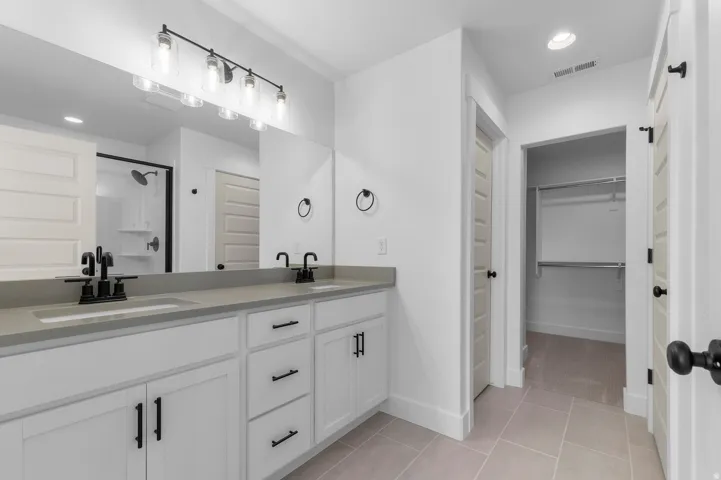 Dual vanity with white cabinetry, matte black fixtures, and light gray countertops