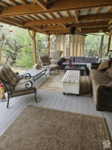 Covered outdoor covered deck featuring a wood-beam ceiling, exposed wood framing, and wood-finish flooring