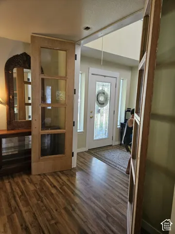 Entryway featuring wood-finish flooring, a white front door with decorative glass, and sidelight windows