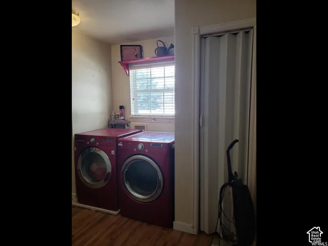 Laundry area featuring wood-finish flooring, a window with blinds, and a built-in floating shelf