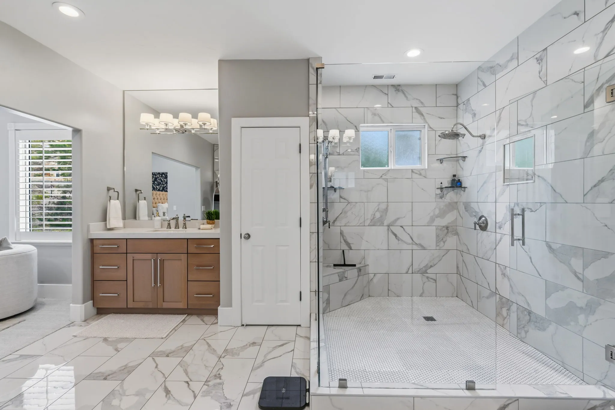 Spacious primary bath with two separate vanities, abundant cabinetry and dedicated linen storage.