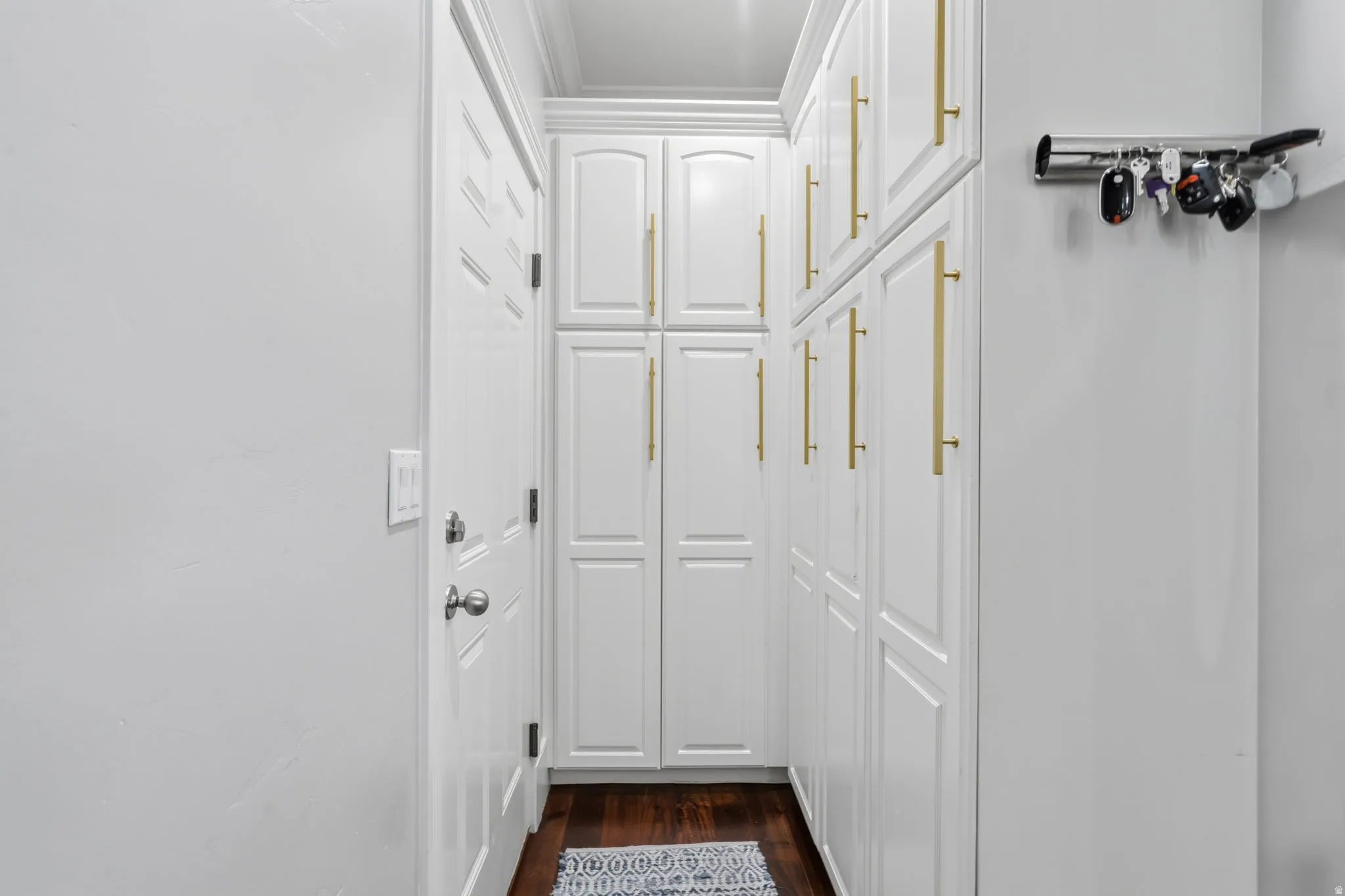 Floor-to-ceiling white cabinetry with gold-finish hardware