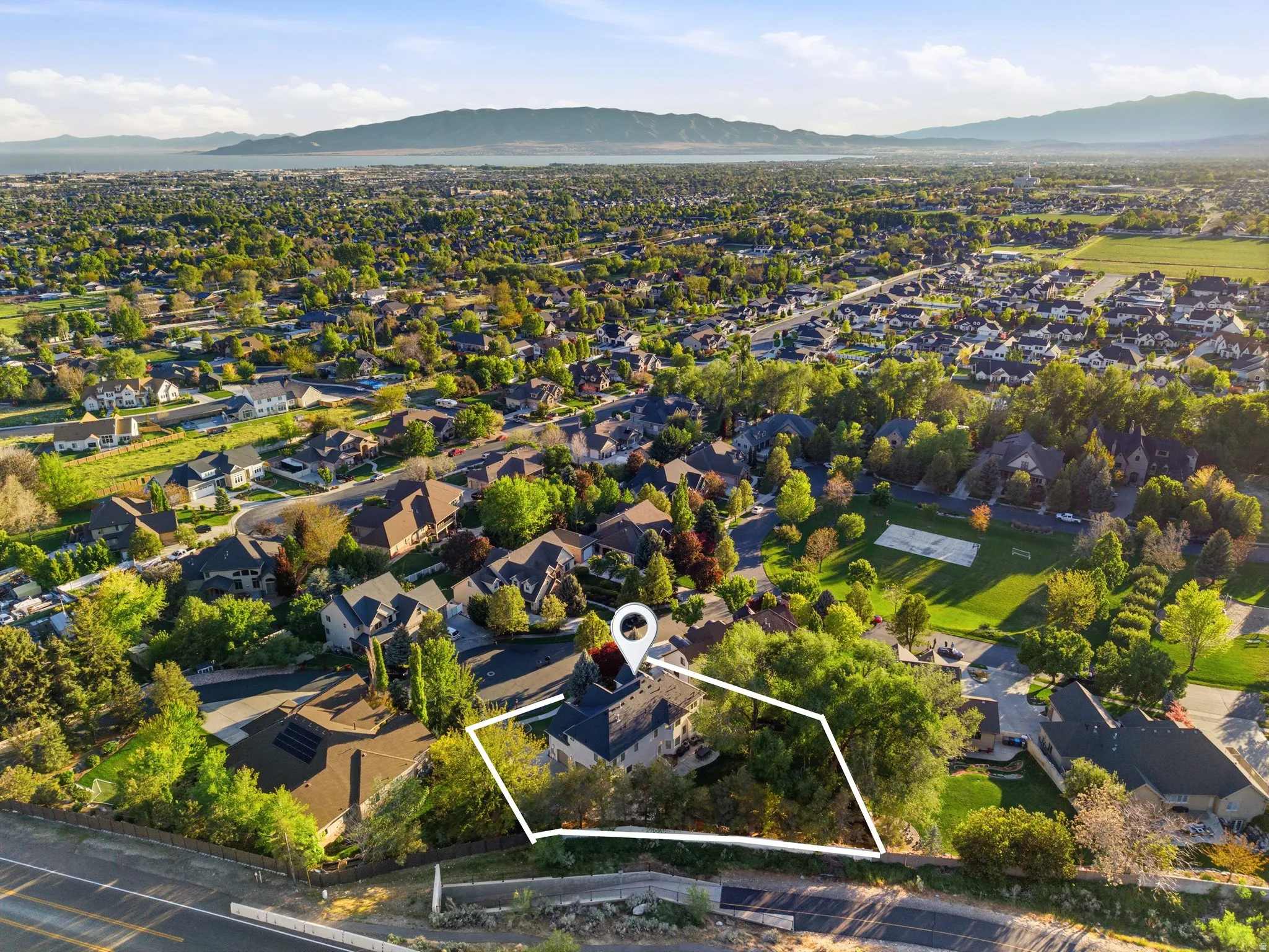 Aerial View of Expansive residential area featuring numerous single-family homes with mature trees and green spaces