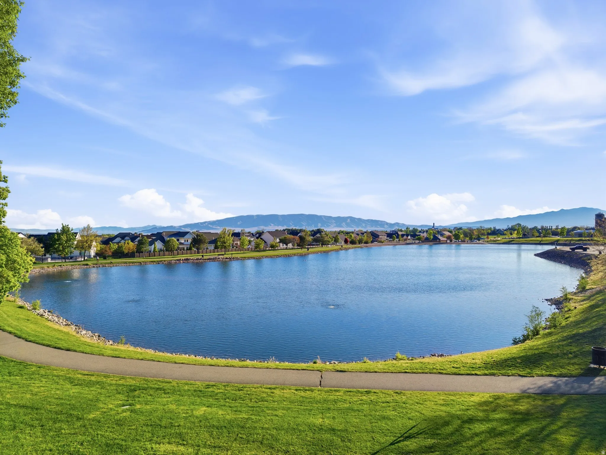 Expansive lakefront setting with a paved walking path and lush green grass just outside the gated neighborhood.  Such a fun place for kids to play and feed ducks!