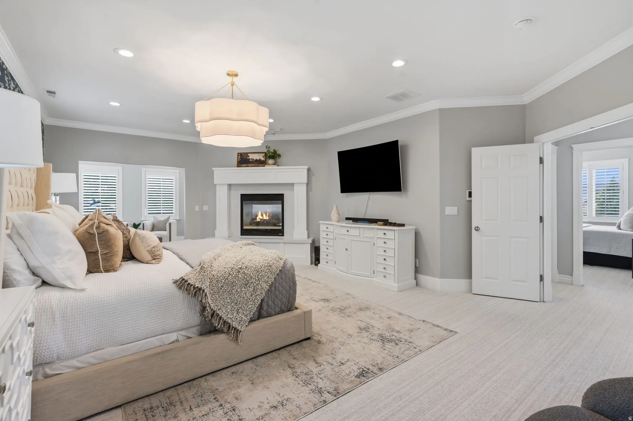 Expansive primary retreat entered thru double doors, featuring 9-foot ceilings, recessed lighting and a statement chandelier
