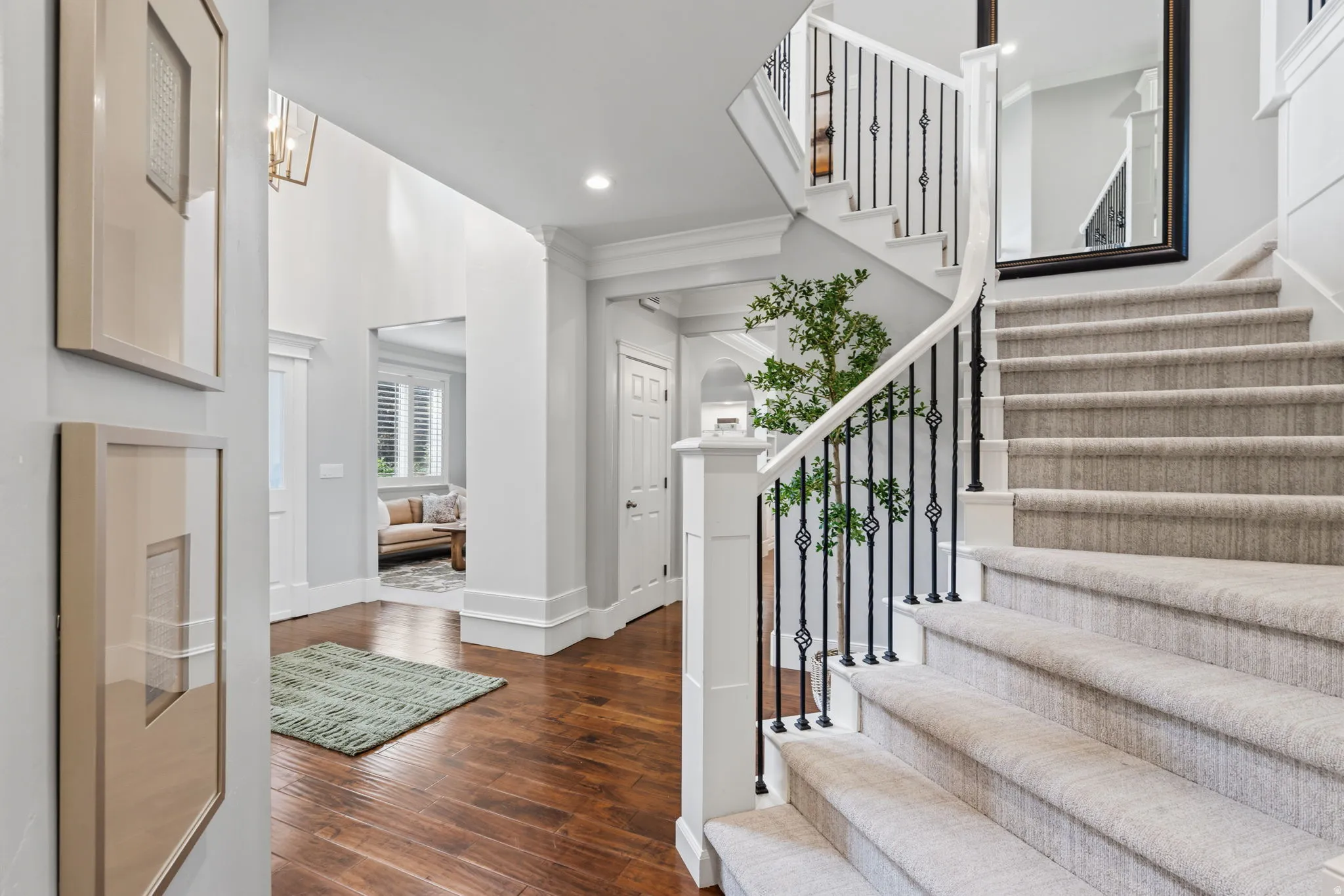 Grand entry foyer with wood-finish flooring and a curved staircase featuring carpeted treads