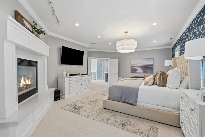 A cozy 2-way fireplace (shared with the primary bathroom) with raised hearth adds warmth and character to this light-filled primary bedroom