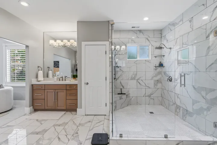 Spacious primary bath with two separate vanities, abundant cabinetry and dedicated linen storage.