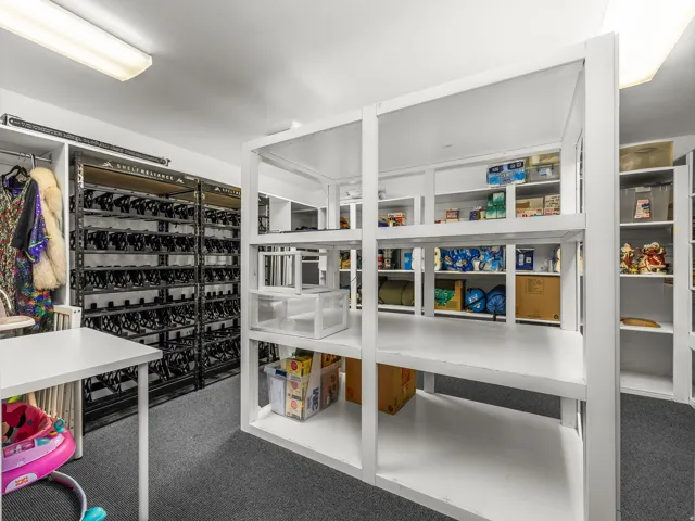 Exceptional storage room with extensive shelving on all four walls, center shelving, and dedicated space for oversized storage bins.