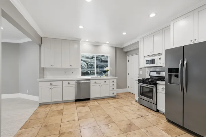 Kitchen sink overlooks a large rock window well for added natural light, with generous pantry and nearby stackable laundry.
