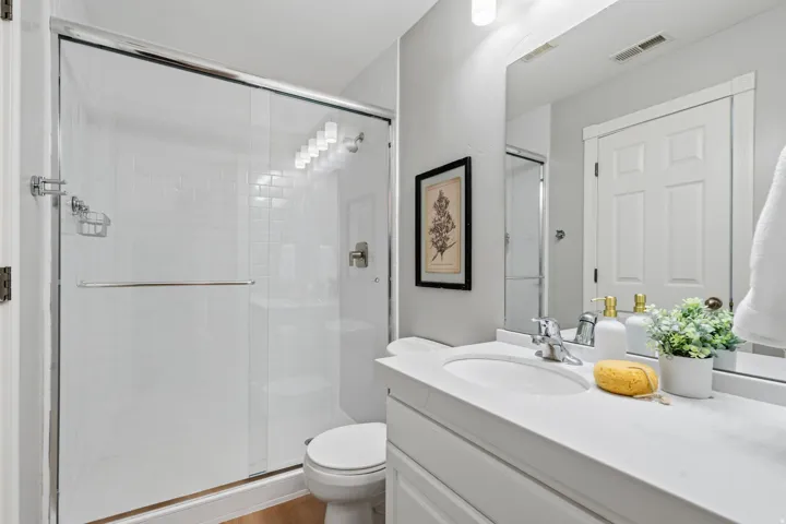 Bedroom #2 Private en suite features a walk-in shower with glass door and classic whit subway tile.