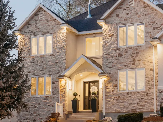Stunning Stone Exterior with manicured landscape and beautiful exterior lighting
