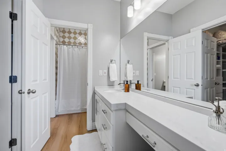 Bedroom # 3 Private vanity features abundant cabinetry and a dedicated seated makeup space.  Generous walk-in closet with built-in drawers, open shelving, additional shoe storage and ample hanging space.