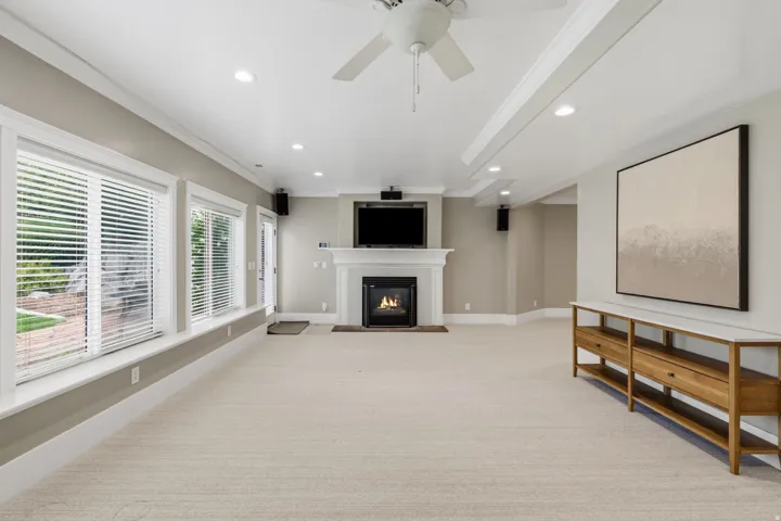 Cozy fireplace with hearth and built-in cabinetry make this a comfortable second gathering space,