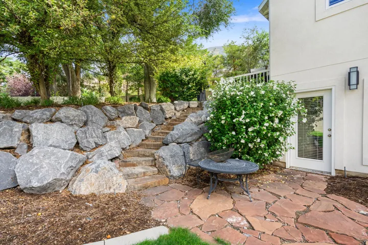 Side yard with integrated stone steps, flagstone patio, and access to Basement.  Possible ADU