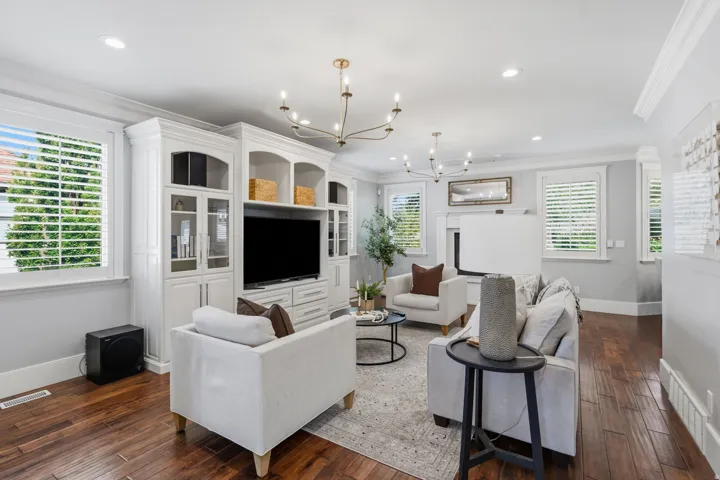 Bright, inviting family room with 9-foot ceilings, two chandeliers, recessed lighting and four large windows with plantation shutters.