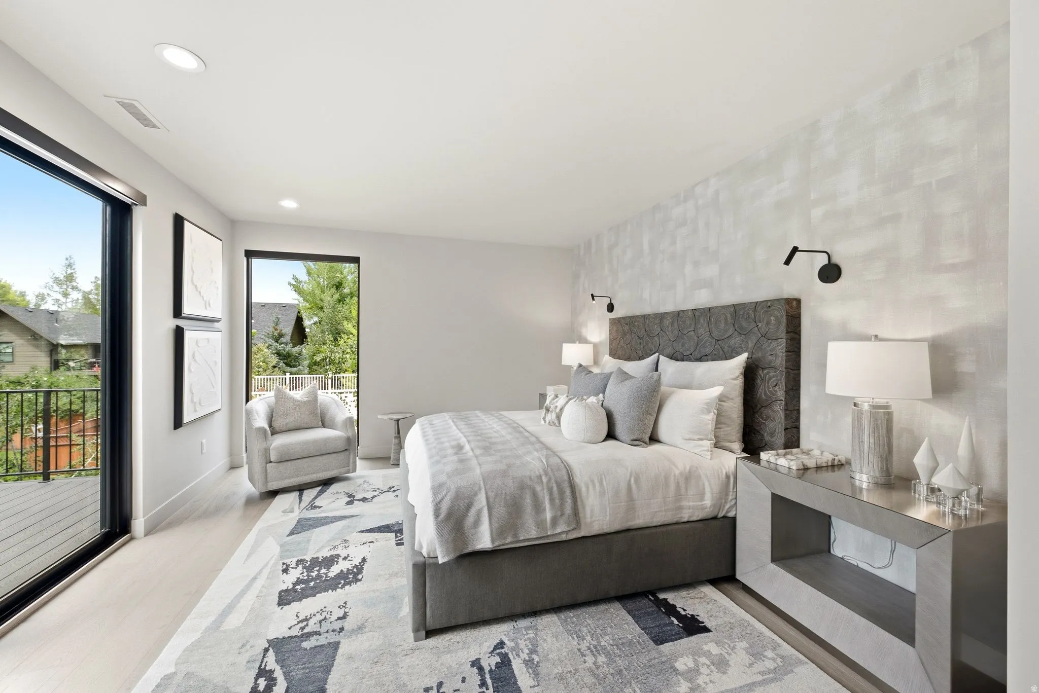 Contemporary room featuring light wood-finish flooring and a textured accent wall