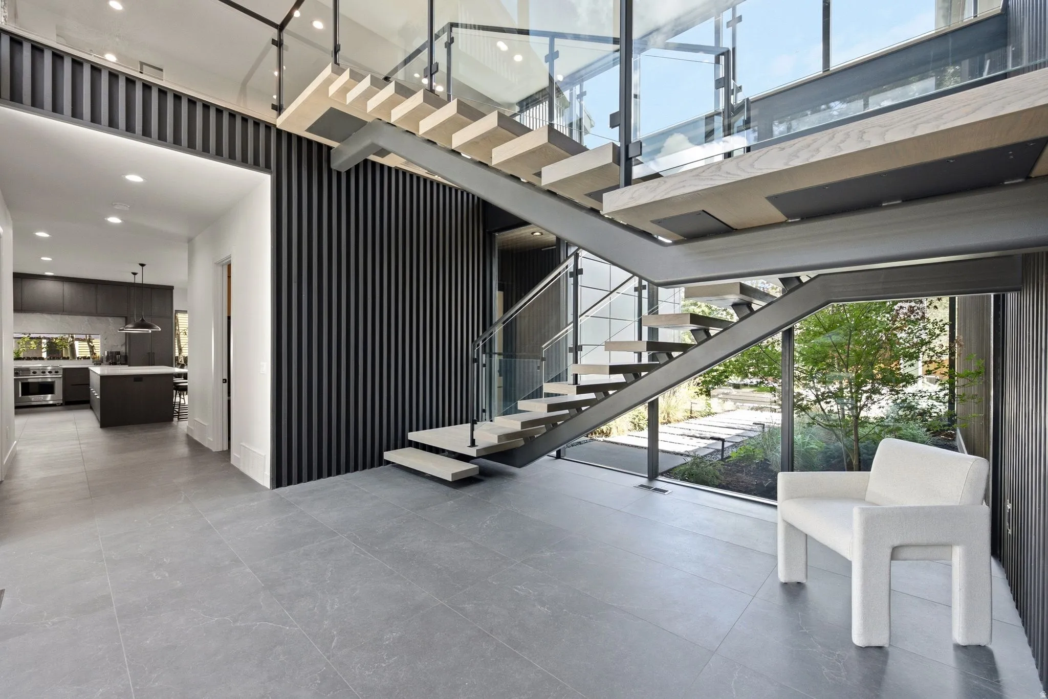 Open-tread staircase with glass railing and wood-finish steps