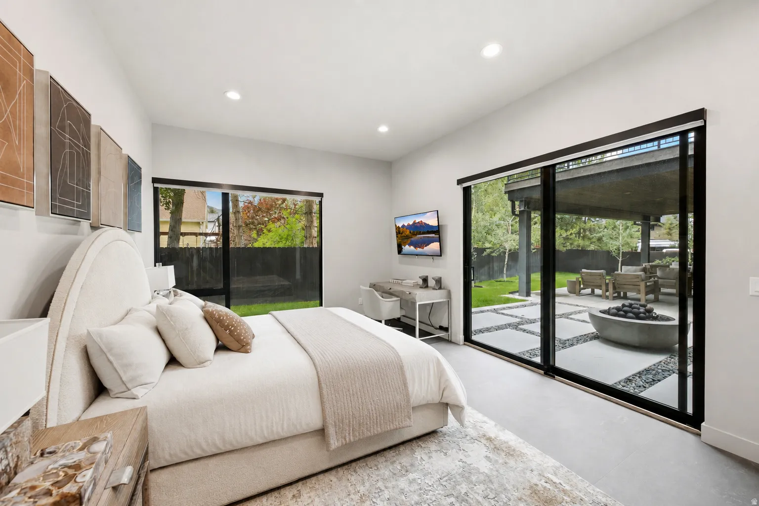 Spacious room featuring floor-to-ceiling sliding glass doors, a secondary window, recessed lighting, and a neutral color palette