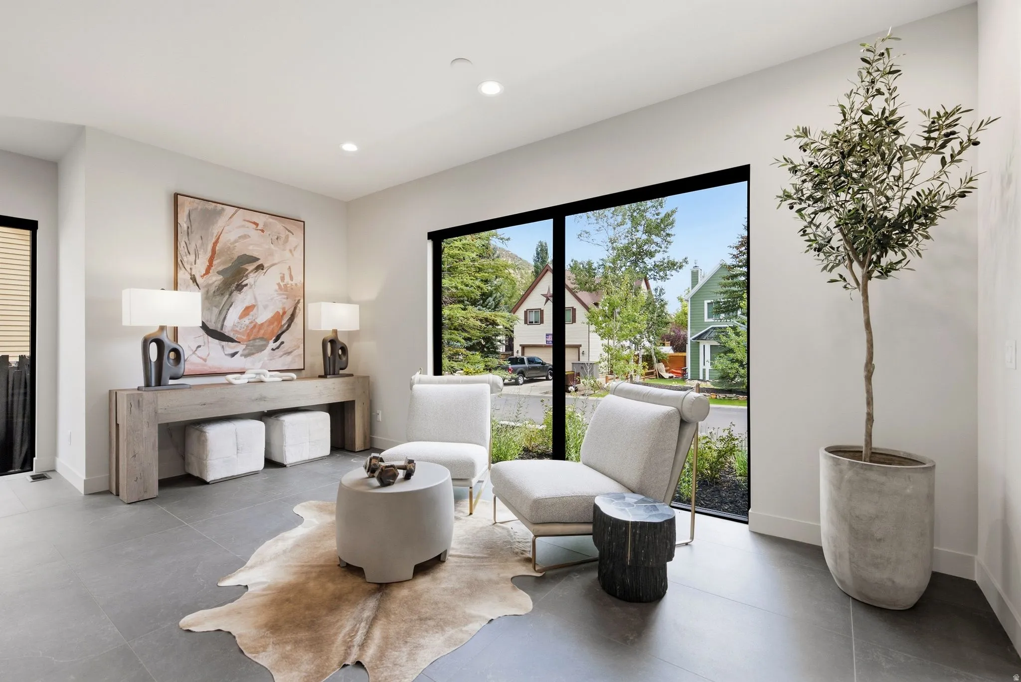 Modern interior featuring a large picture window, recessed lighting, and grey tile flooring