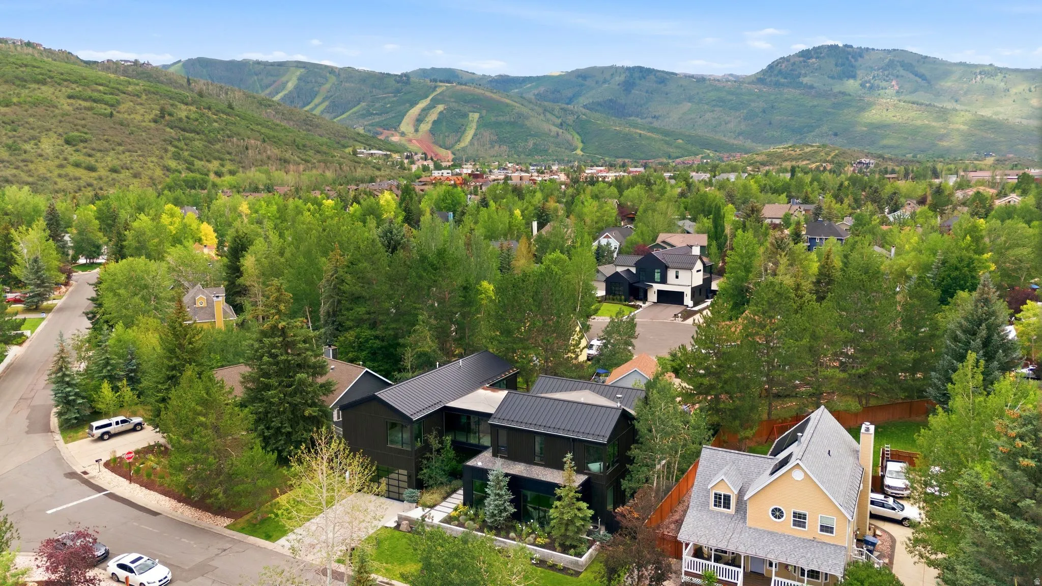 Contemporary multi-story residence featuring a dark exterior and metal roofing