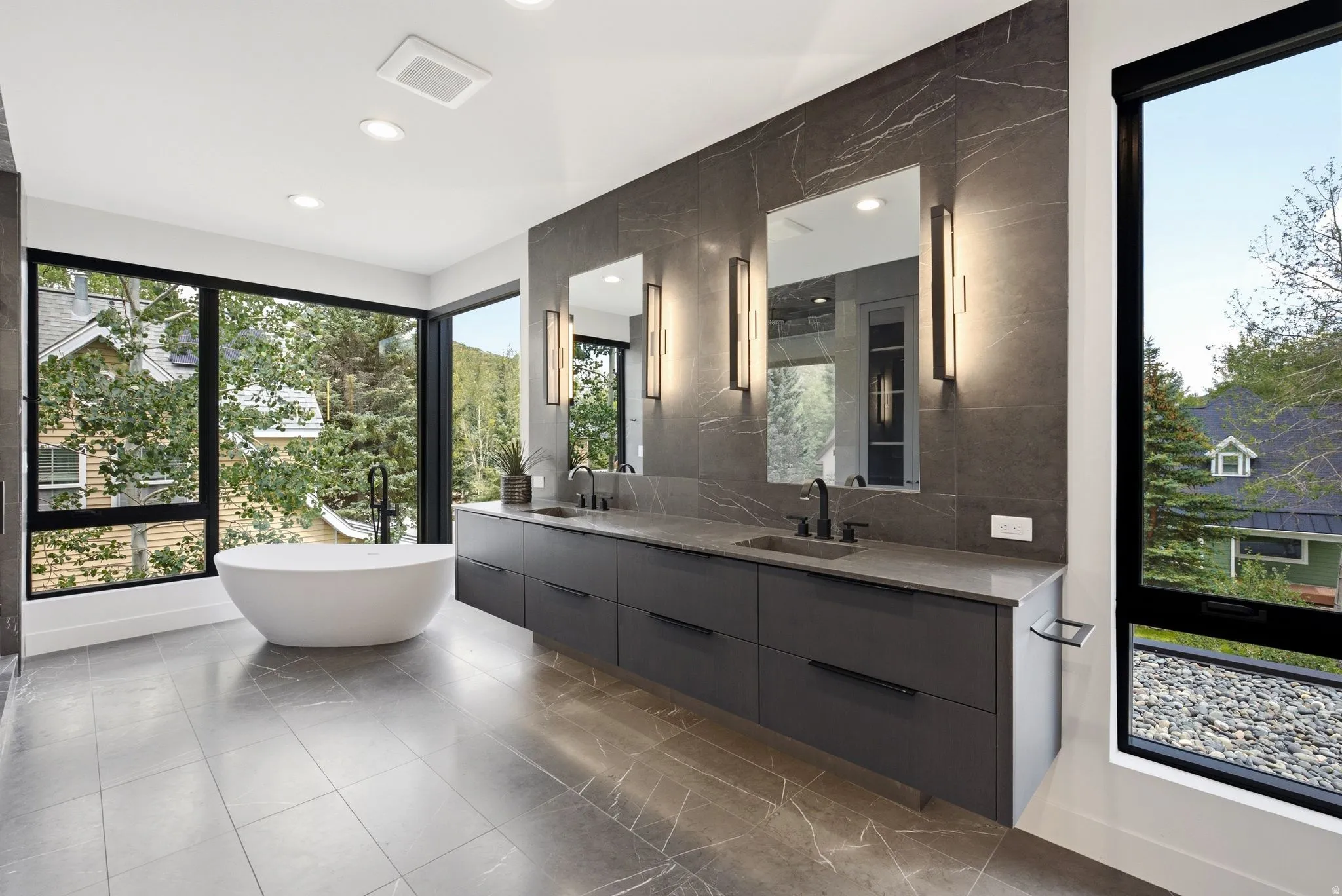 Modern bathroom featuring a freestanding soaking tub and floor-to-ceiling windows