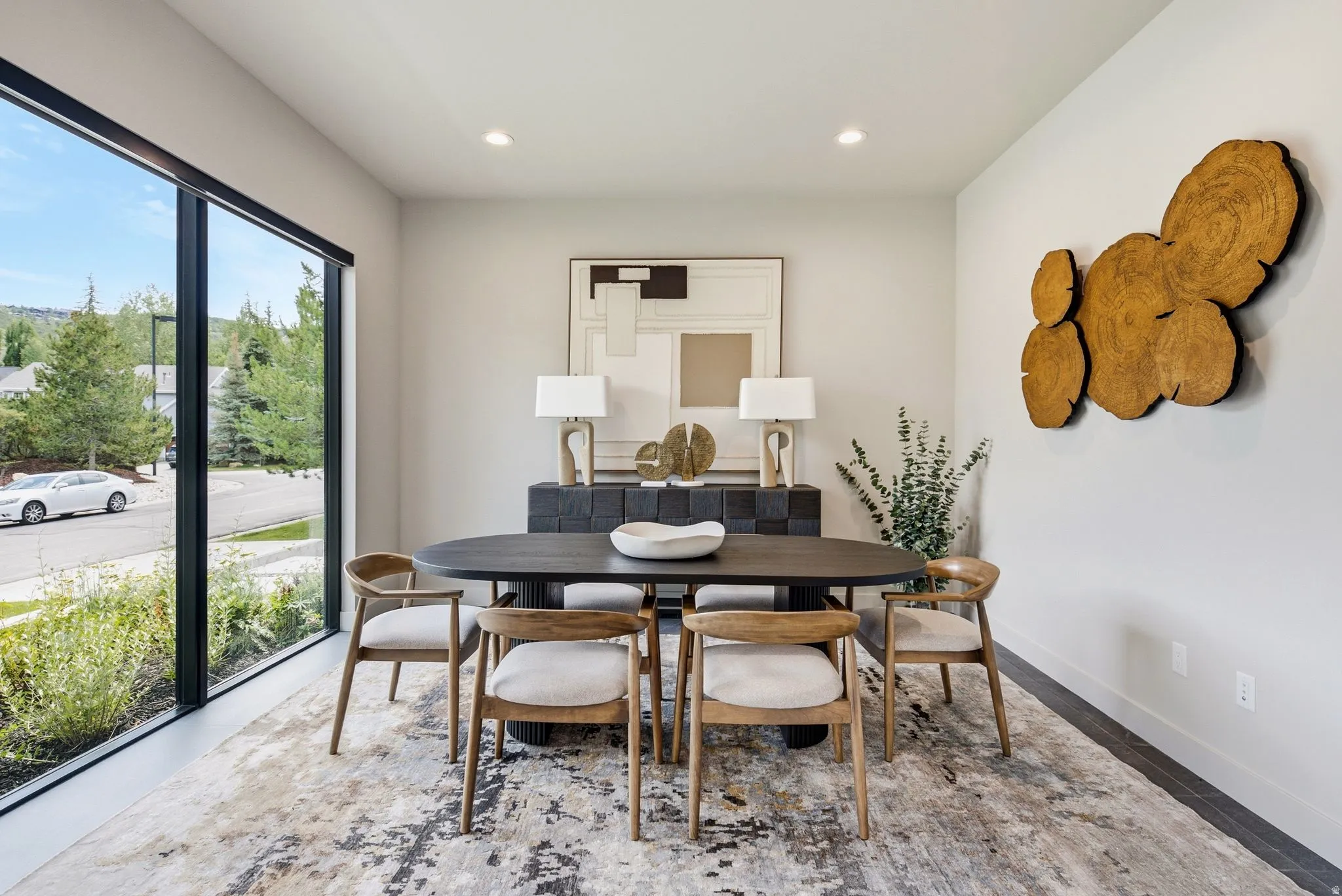 Open-concept dining area featuring a large picture window, recessed lighting, neutral wall tones, and dark wood-finish flooring