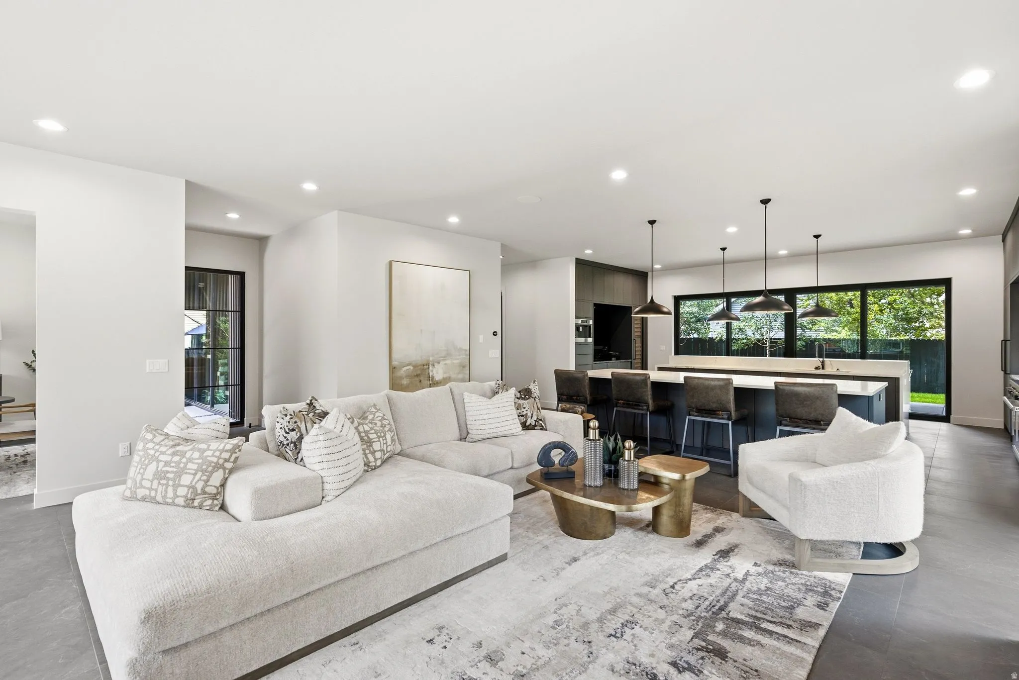 Open-concept living space featuring recessed lighting, a large kitchen island with seating, pendant lighting, and expansive windows