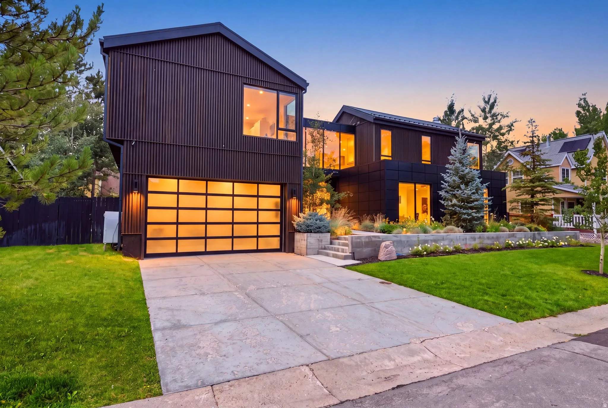 Modern architectural exterior featuring dark corrugated siding and expansive windows